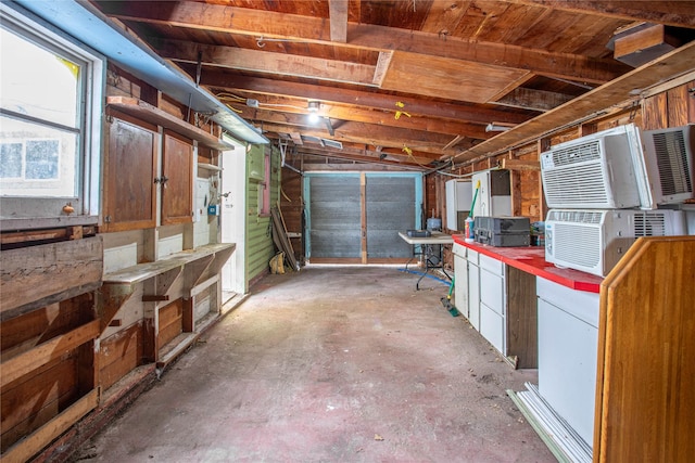 misc room with a wall mounted AC, a workshop area, and concrete floors