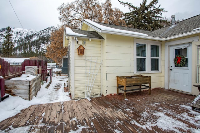 snow covered deck featuring a mountain view