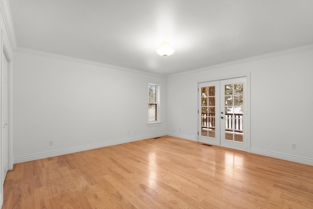 empty room featuring ornamental molding, light wood-type flooring, and french doors