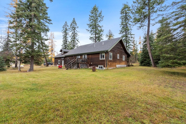 rear view of property with a wooden deck and a lawn