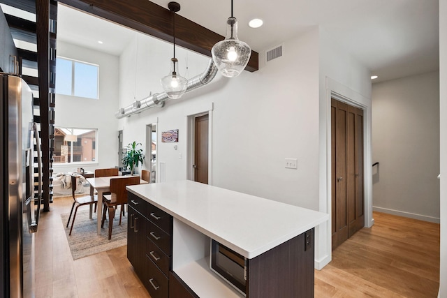 141 Hawthorne Ct Unit A, Whitefish, MT 59937 - kitchen featuring light countertops, appliances with stainless steel finishes, light wood-style flooring, a kitchen island, and recessed lighting