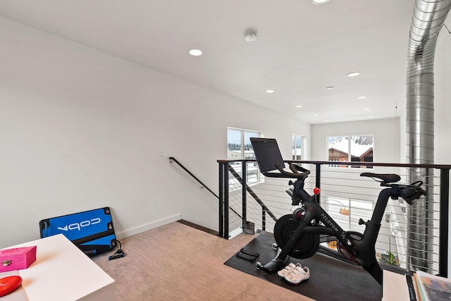 exercise area with a wealth of natural light and light carpet