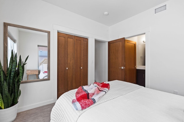 carpeted bedroom with a closet and ensuite bath