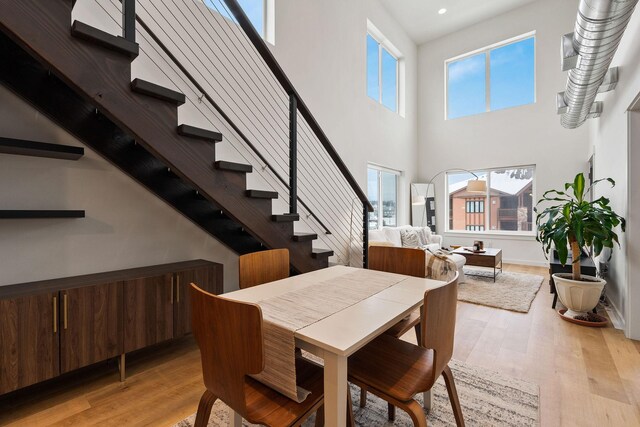 141 Hawthorne Ct Unit A, Whitefish, MT 59937 - dining space featuring light wood-type flooring, stairs, recessed lighting, and a high ceiling