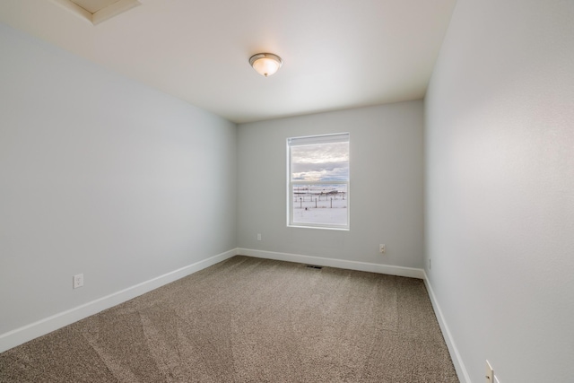 carpeted spare room with visible vents and baseboards