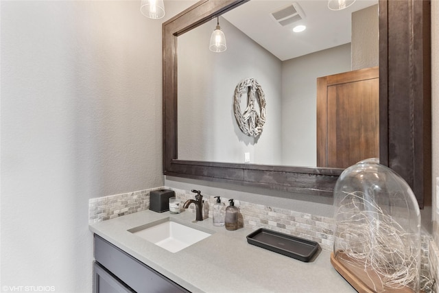 bathroom with vanity and tasteful backsplash