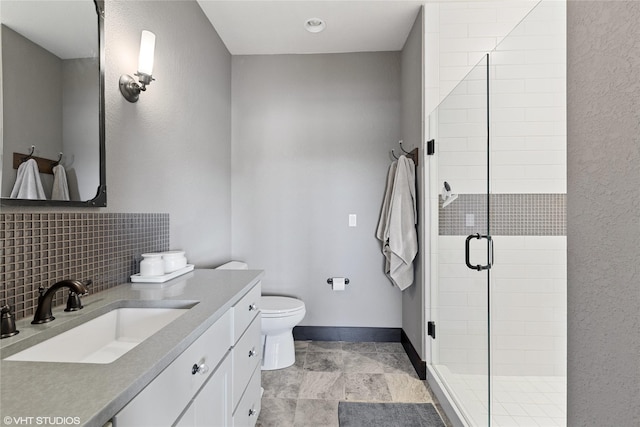 bathroom with a shower with door, vanity, tasteful backsplash, and toilet