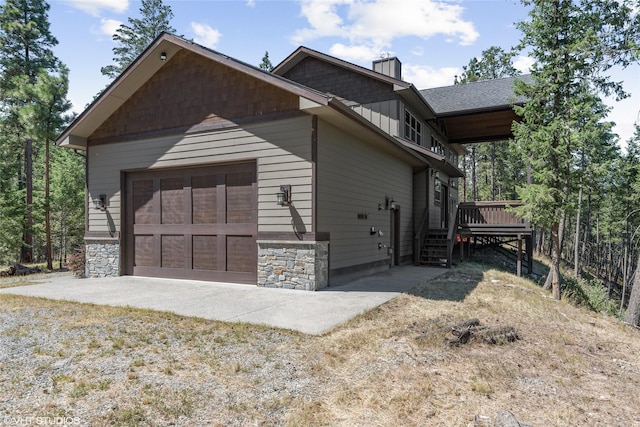 view of property exterior with a deck and a garage