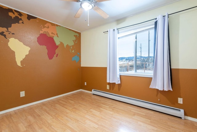 unfurnished room with ceiling fan, light hardwood / wood-style flooring, and a baseboard heating unit