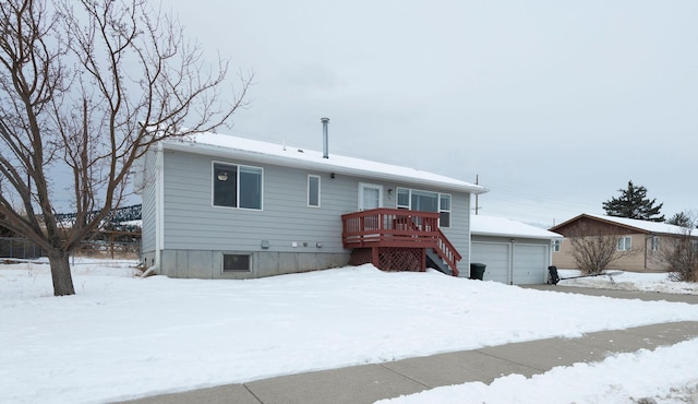 view of front of house featuring a garage, a wooden deck, and an outbuilding