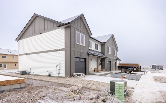 view of side of home with central AC and a garage