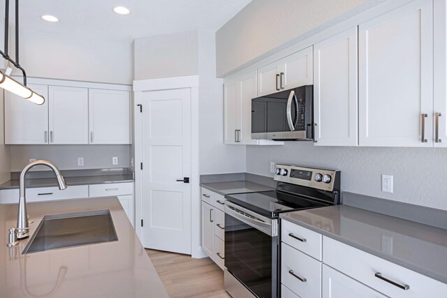 kitchen featuring white cabinets, light hardwood / wood-style floors, a kitchen island, and beam ceiling