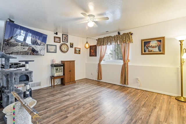 interior space with ceiling fan, a textured ceiling, and hardwood / wood-style flooring