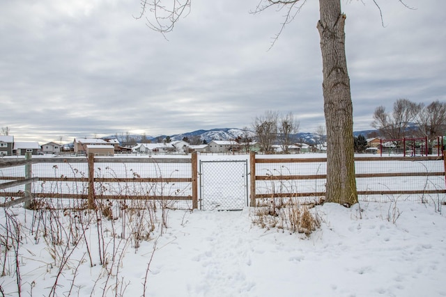 yard covered in snow featuring a mountain view