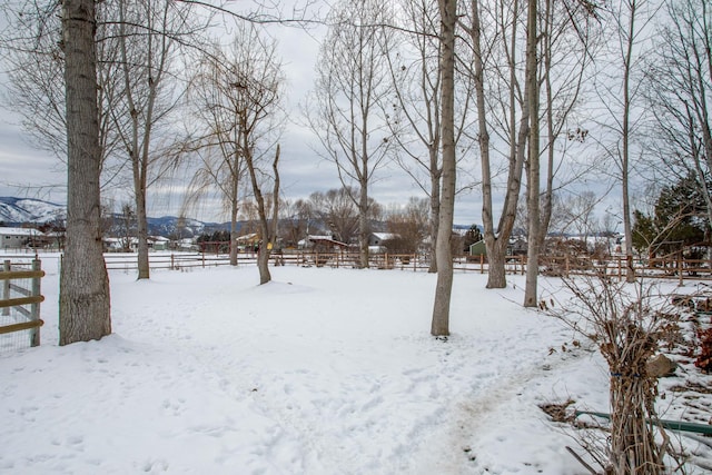 yard covered in snow featuring a mountain view