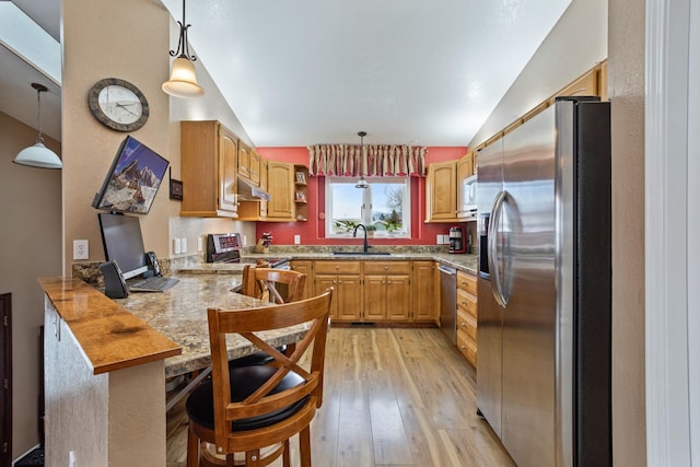 kitchen featuring sink, stainless steel appliances, kitchen peninsula, and hanging light fixtures