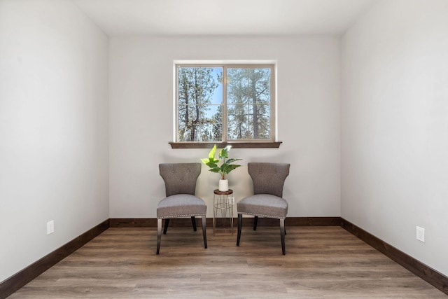 living area with baseboards and wood finished floors