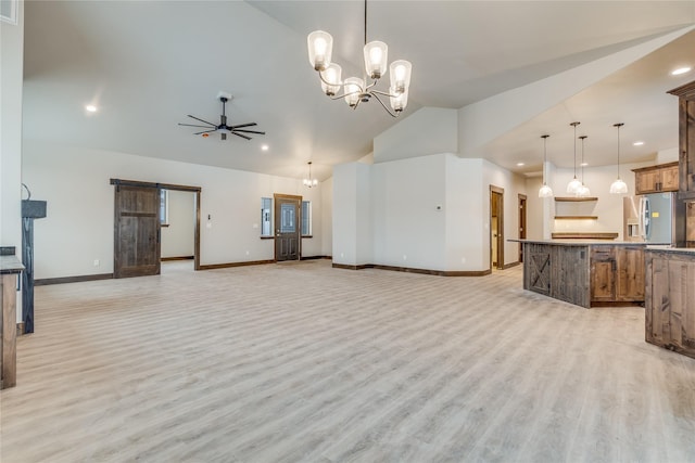 living room with ceiling fan with notable chandelier, a barn door, light hardwood / wood-style flooring, and lofted ceiling