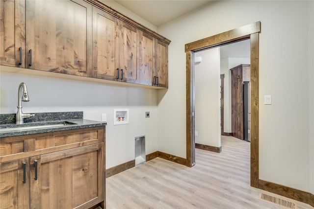 laundry area with electric dryer hookup, visible vents, a sink, light wood finished floors, and hookup for a washing machine