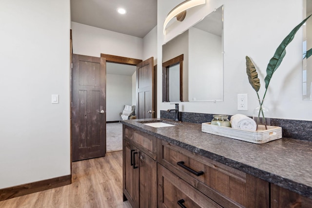 bathroom with baseboards, wood finished floors, and vanity