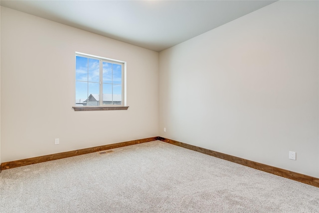 unfurnished room featuring visible vents, baseboards, and carpet