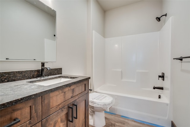 full bathroom with toilet, hardwood / wood-style flooring, bathtub / shower combination, and vanity