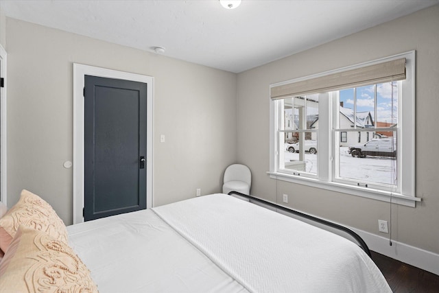 bedroom with wood finished floors and baseboards