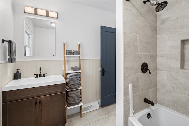 bathroom featuring tile patterned floors, vanity,  shower combination, and wainscoting