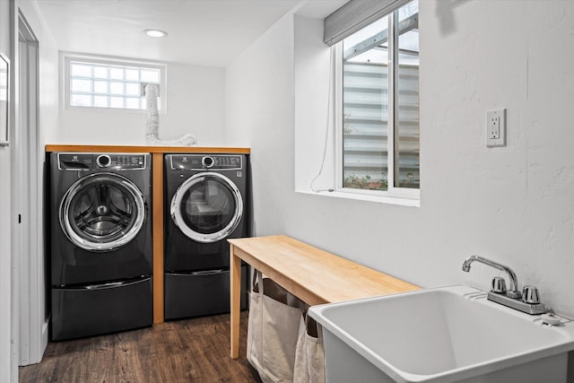 washroom with a sink, independent washer and dryer, dark wood-style flooring, and laundry area