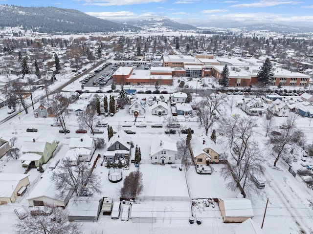 snowy aerial view with a mountain view and a residential view