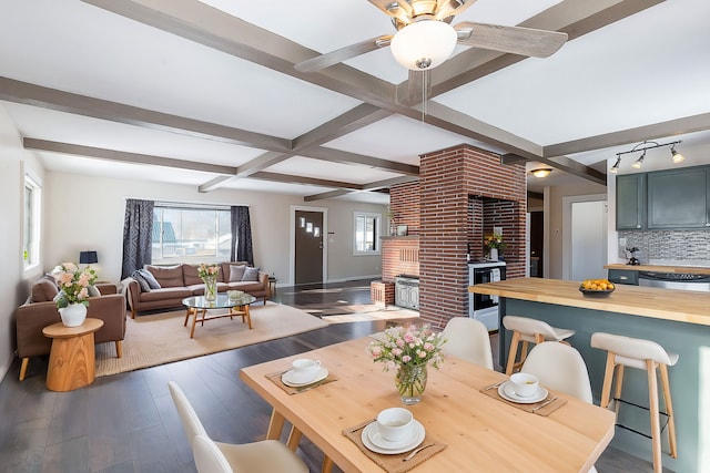 dining room with beam ceiling, ceiling fan, and dark hardwood / wood-style floors