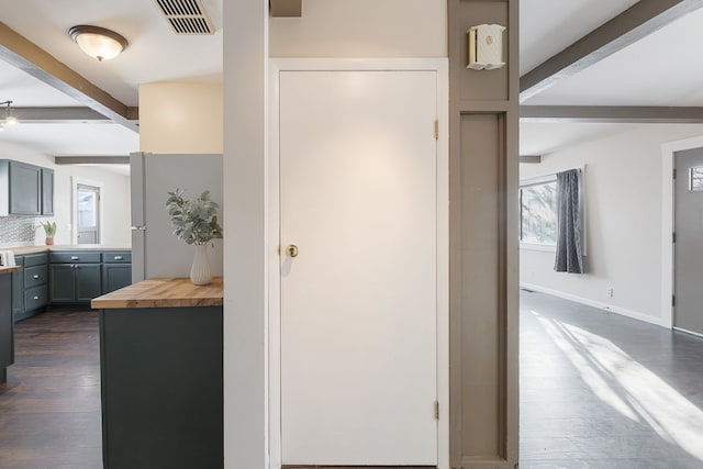 corridor featuring dark hardwood / wood-style flooring and beamed ceiling