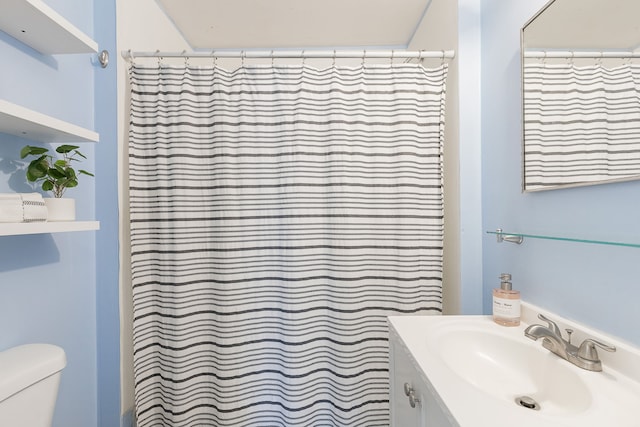 bathroom with a shower with curtain, vanity, and toilet