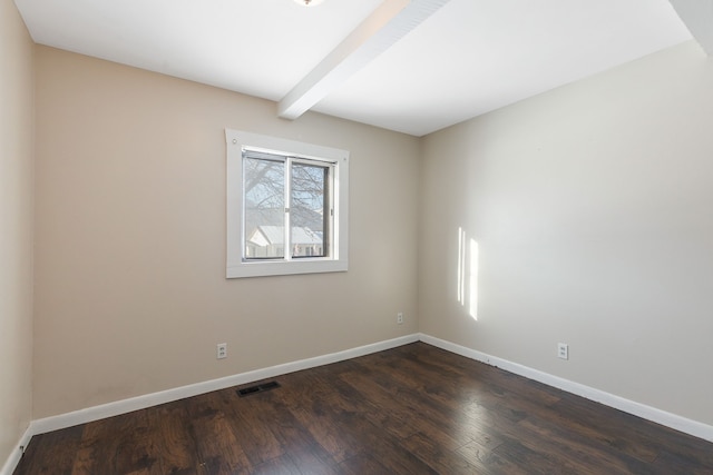 empty room with dark hardwood / wood-style floors and beamed ceiling