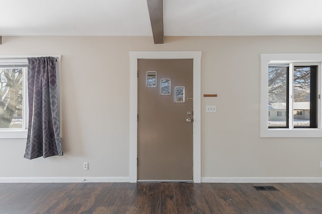 entryway featuring beam ceiling and dark wood-type flooring