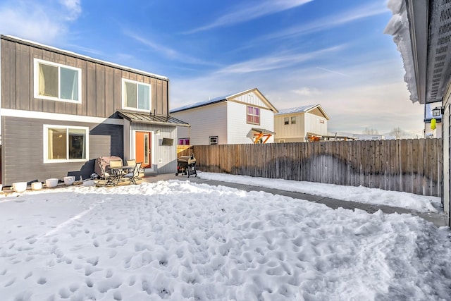 view of snow covered rear of property