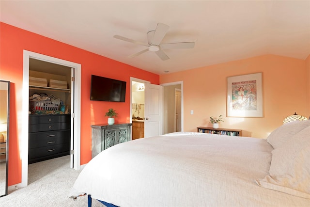 carpeted bedroom with ensuite bathroom, ceiling fan, and a closet