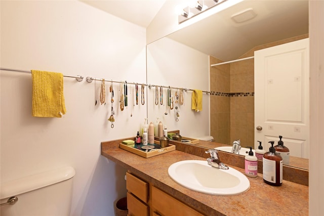 bathroom with toilet, vanity, and lofted ceiling