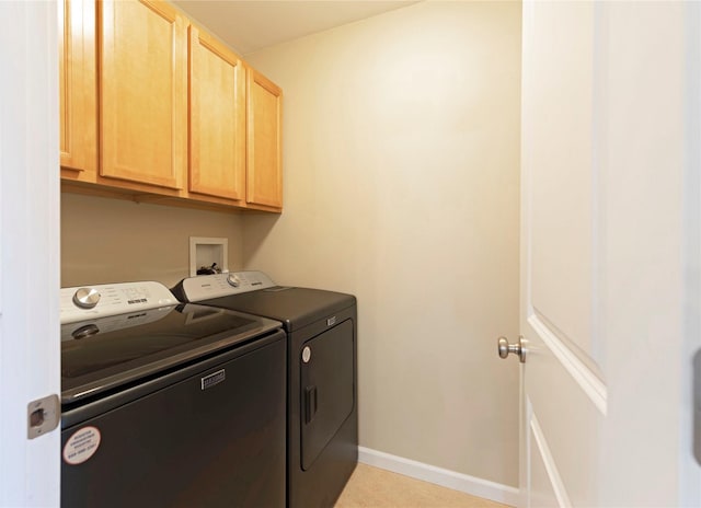 clothes washing area featuring cabinets and independent washer and dryer