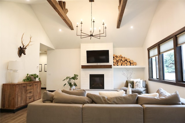 living room featuring lofted ceiling with beams, a large fireplace, hardwood / wood-style floors, and a notable chandelier