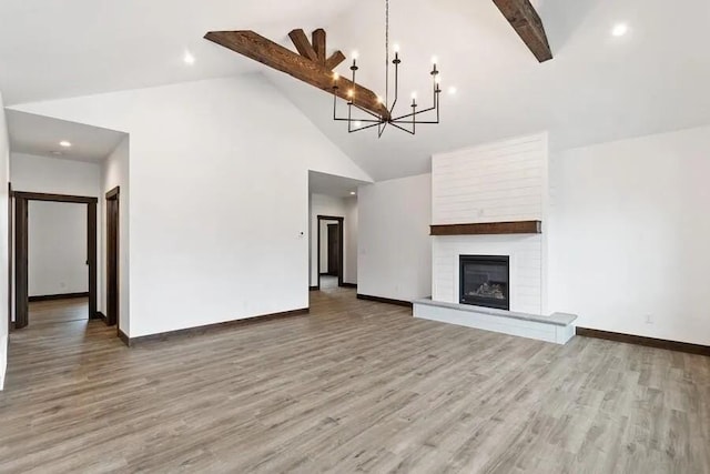 unfurnished living room with high vaulted ceiling, a large fireplace, hardwood / wood-style floors, and beam ceiling