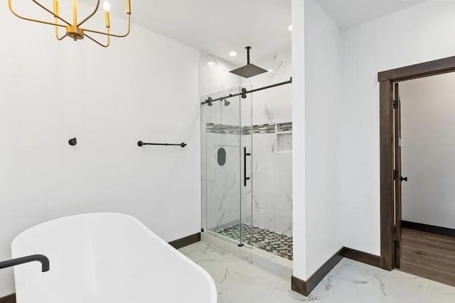 bathroom with an inviting chandelier and shower with separate bathtub