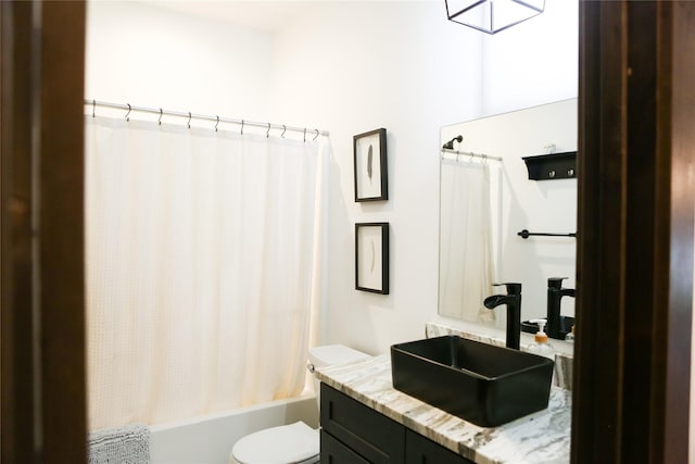 full bathroom with vanity, shower / bath combo with shower curtain, and toilet