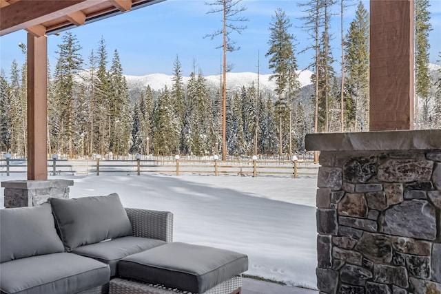 190 Black Bear Ln, Bigfork, MT 59911 - snow covered patio featuring a forest view, a patio, and a mountain view