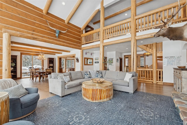 living room featuring a notable chandelier, dark wood-type flooring, a high ceiling, and beamed ceiling