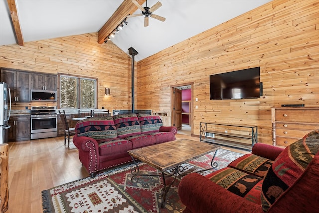 living room featuring high vaulted ceiling, light hardwood / wood-style flooring, wood walls, and beamed ceiling