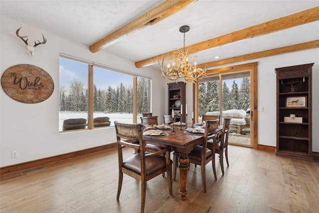 dining area with beam ceiling, a notable chandelier, and hardwood / wood-style flooring