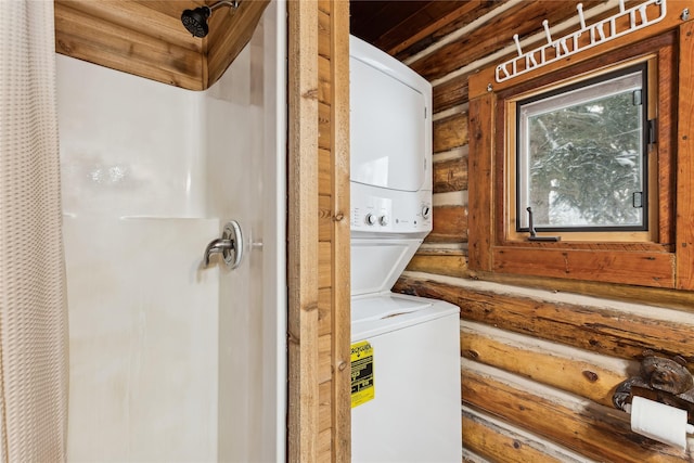 laundry area with stacked washer and clothes dryer and log walls