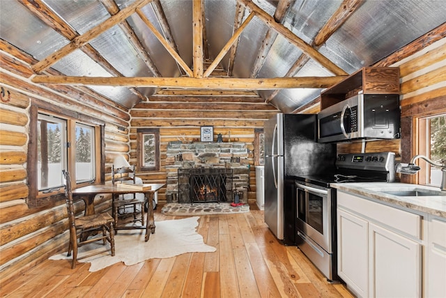 kitchen featuring stainless steel appliances, log walls, vaulted ceiling with beams, white cabinets, and sink