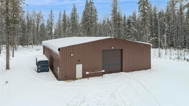 snow covered structure with a garage